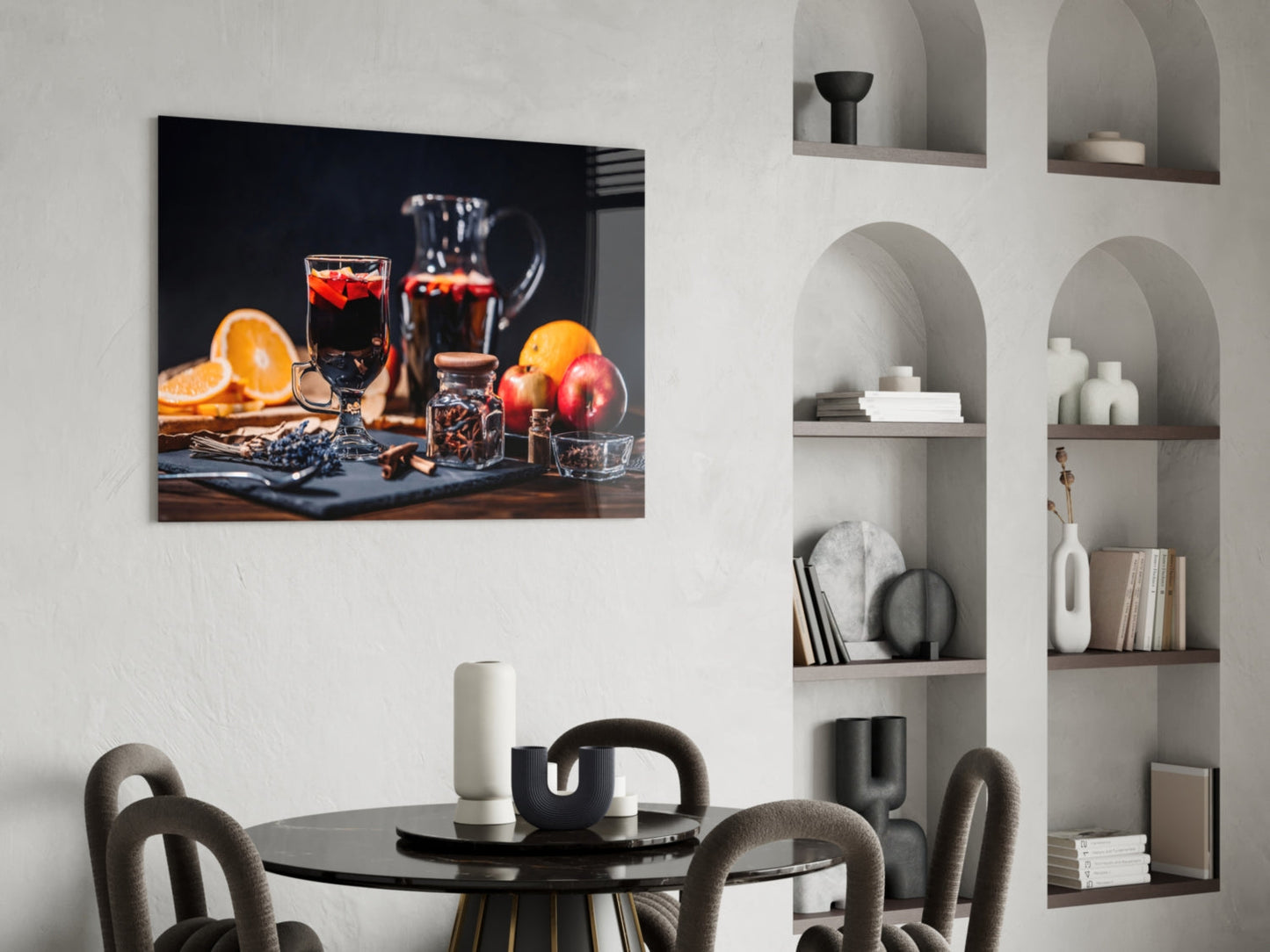 Noel Tea Glass Wall Art displaying a still life of dark liquor, citrus fruits, and glassware mounted above a dining table with chairs.