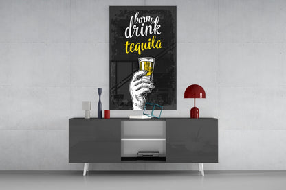 Black framed tequila wall art with white and yellow text displayed above gray media console with red lamp and decorative objects.