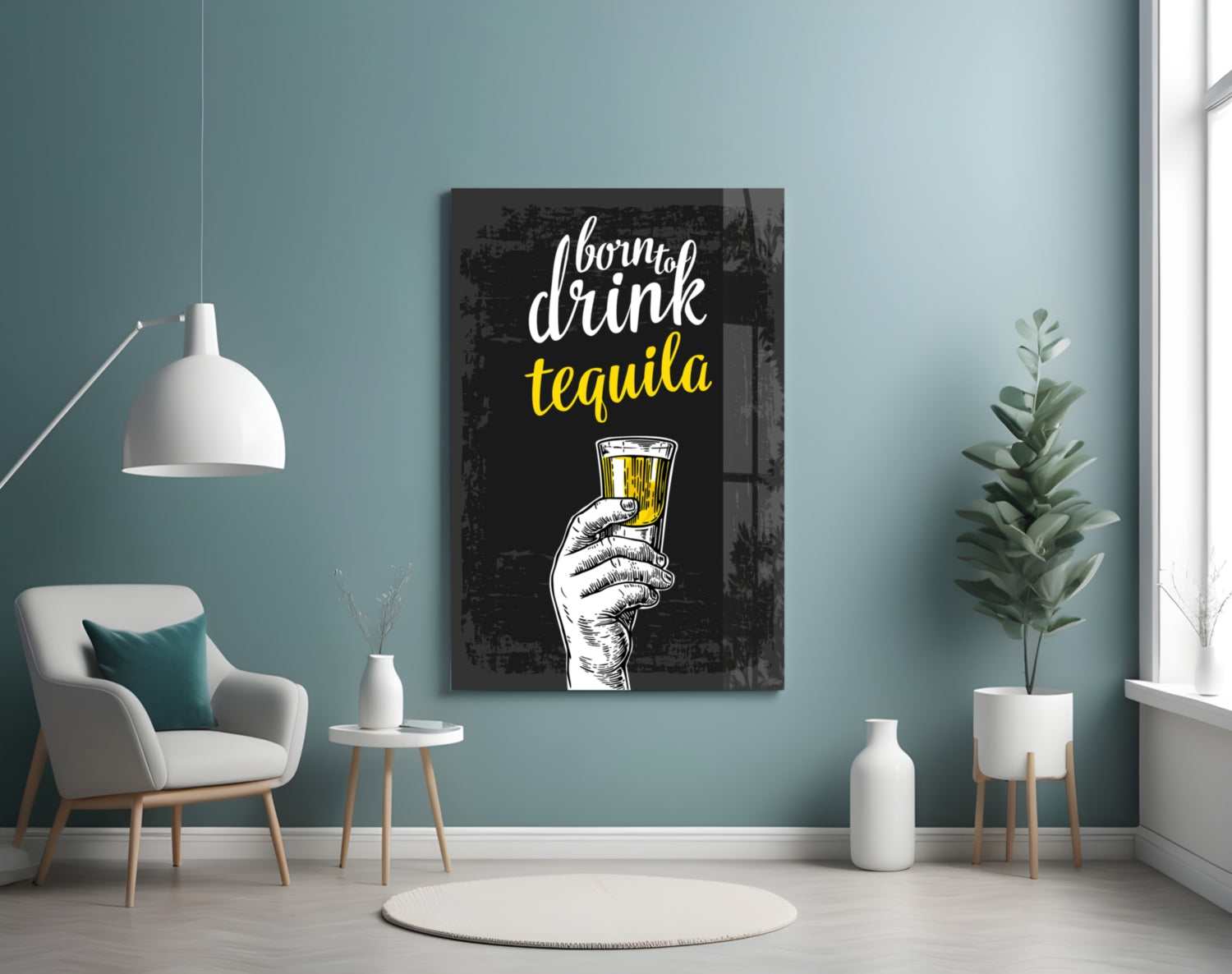 Black canvas tequila wall art with white and yellow text displayed in modern turquoise room with chair and plants.