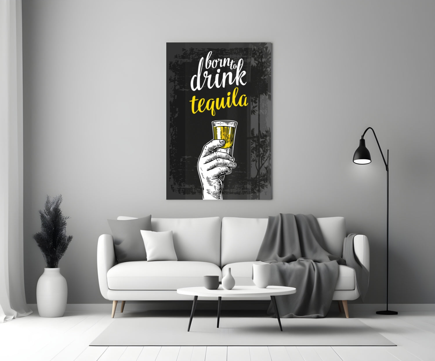 Black canvas wall art with white and yellow text reading "born to drink tequila" and a sketched hand holding a filled glass, displayed above a white sofa in a modern living room.