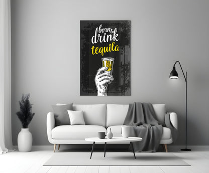 Black canvas wall art with white and yellow text reading "born to drink tequila" and a sketched hand holding a filled glass, displayed above a white sofa in a modern living room.