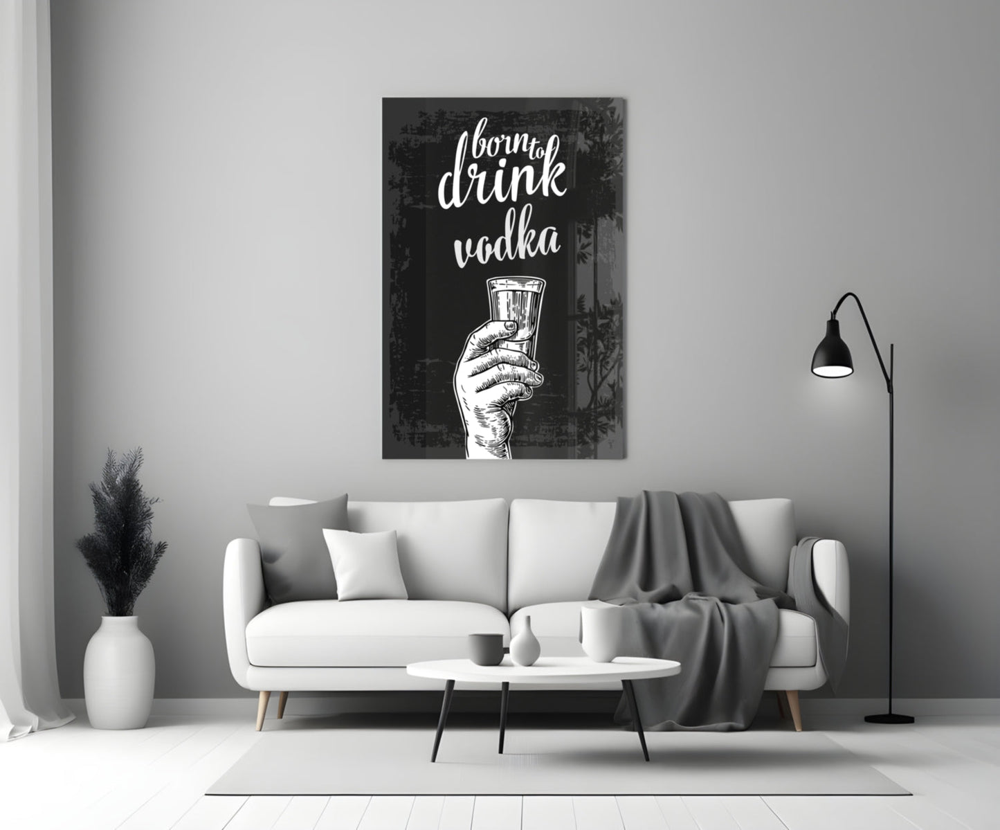 Black canvas with white script text "I born to drink vodka" and hand holding shot glass, displayed above white sofa in modern living room.