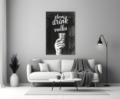 Black canvas with white script text "I born to drink vodka" and hand holding shot glass, displayed above white sofa in modern living room.