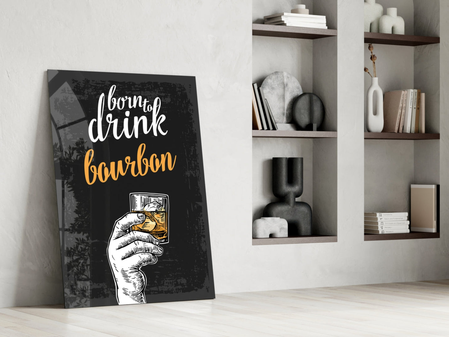 Black canvas bourbon wall art with white and gold text leaning against white wall beside wooden shelves displaying decorative items.
