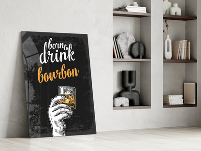 Black canvas bourbon wall art with white and gold text leaning against white wall beside wooden shelves displaying decorative items.