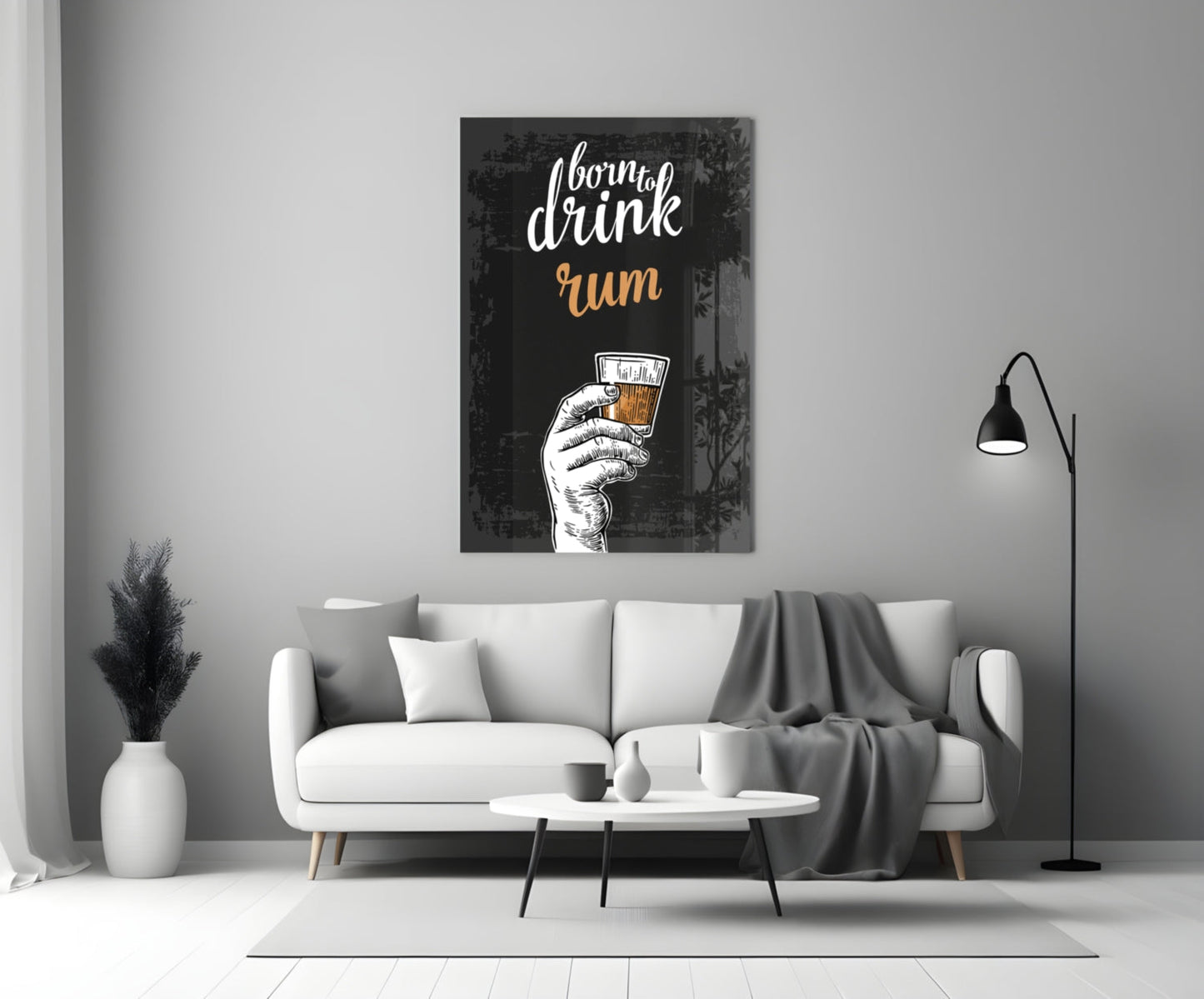 Black canvas rum wall art displaying white script text and illustrated hand holding amber drink, hanging above white sofa in modern living room.