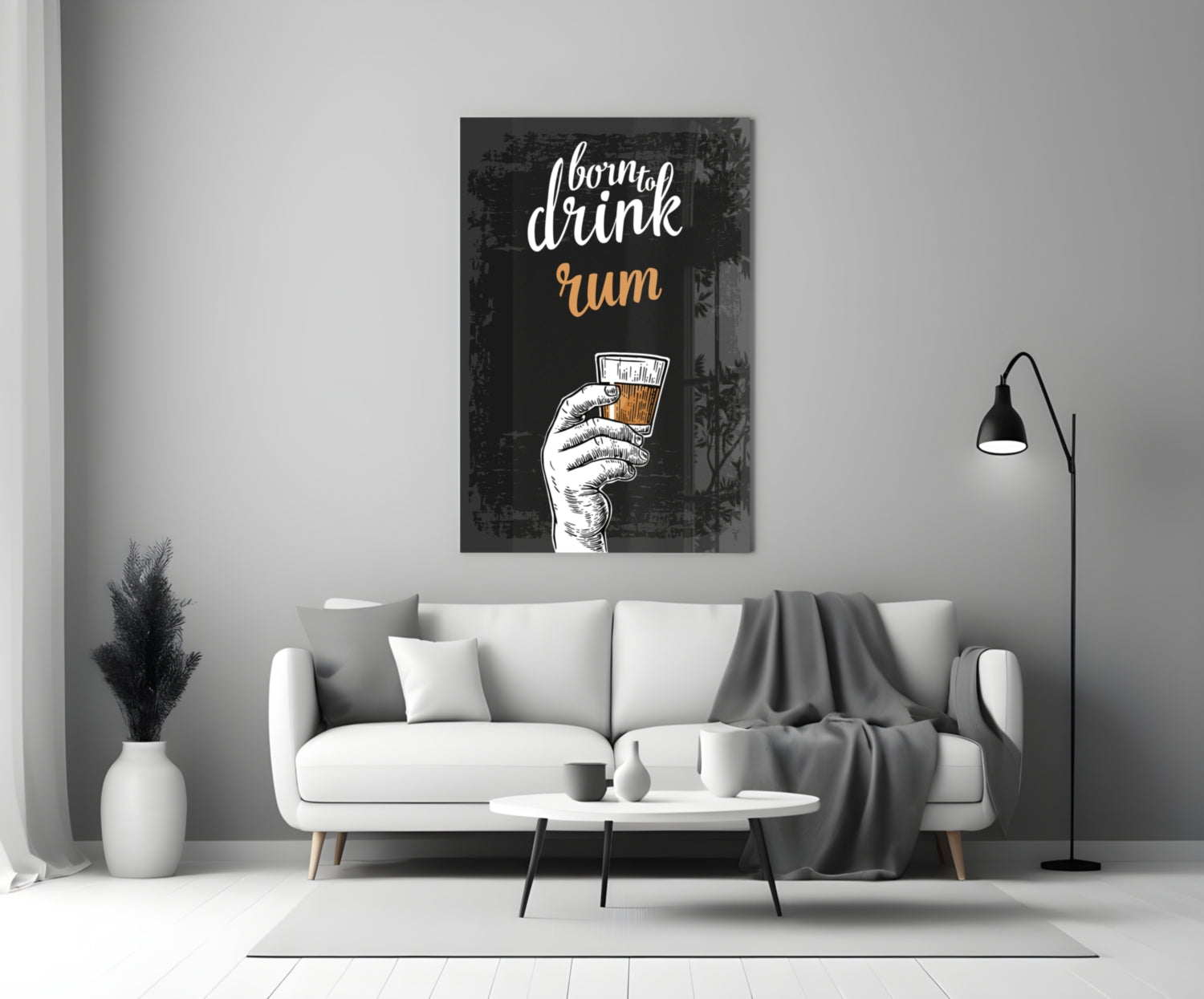 Black canvas rum wall art displaying white script text and illustrated hand holding amber drink, hanging above white sofa in modern living room.