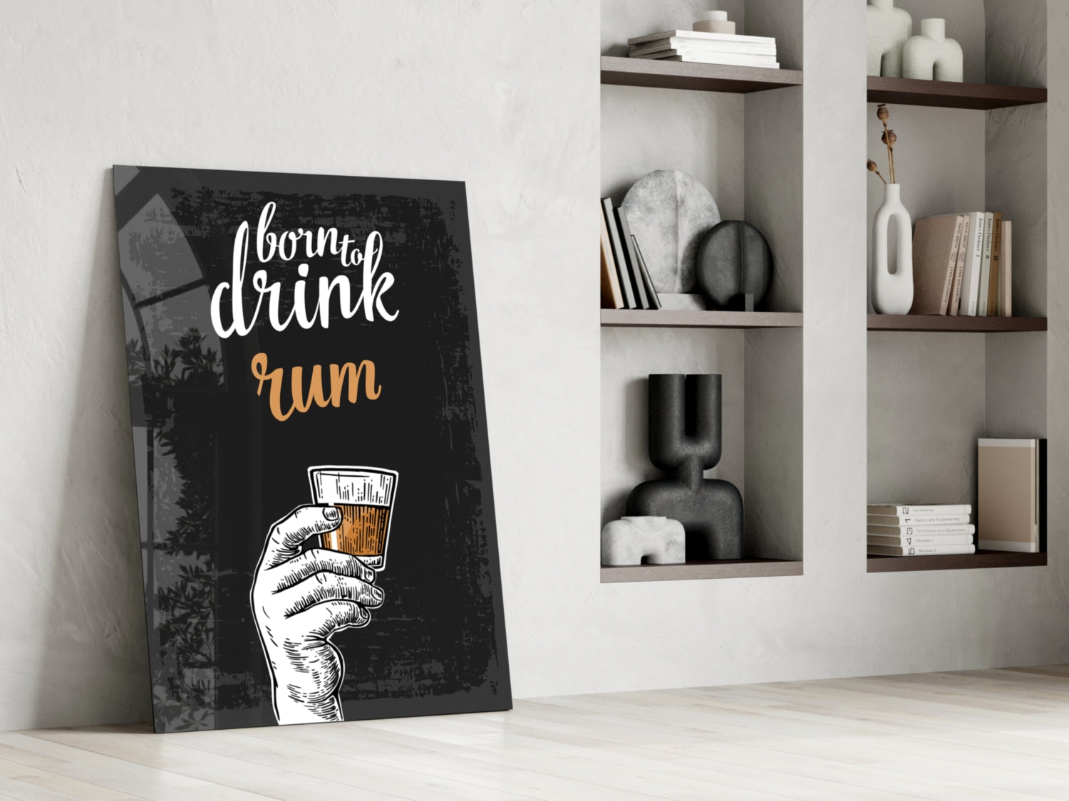 Black canvas rum wall art leaning against white wall beside floating shelves with decorative objects and books.
