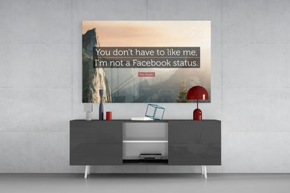 Glass wall art with Wiz Khalifa quote displayed above dark console table with red lamp and decorative items.