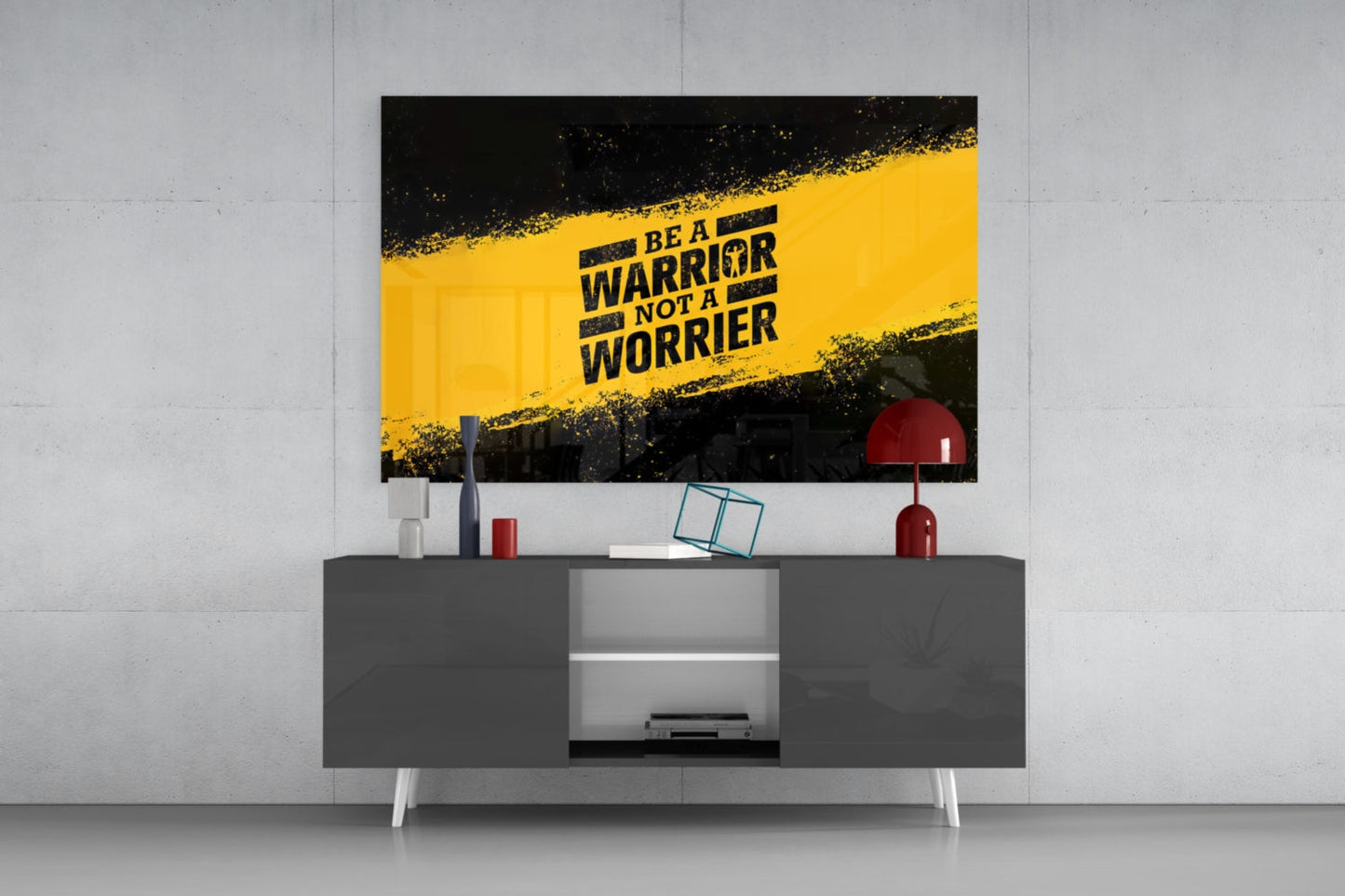 Yellow and black glass wall art with "Be a Warrior Not a Worrier" text displayed above gray media console in modern interior setting.