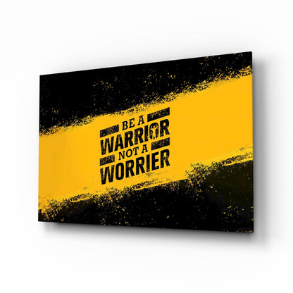 Glass wall art with black and yellow grunge design displaying "Be a Warrior Not a Worrier" text, angled perspective view.