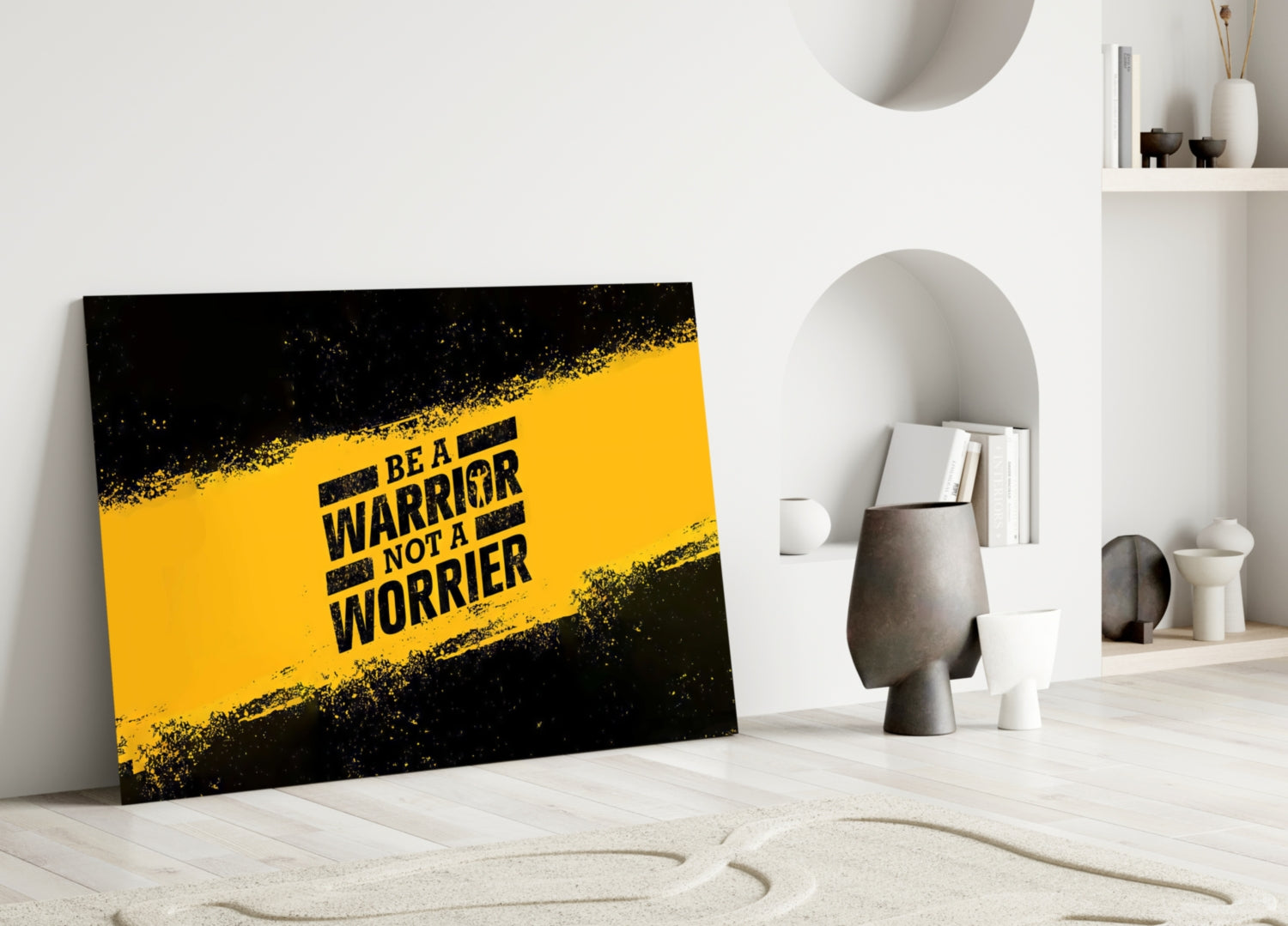 Yellow and black glass wall art with "BE A WARRIOR NOT A WORRIER" text leaning against white interior wall with shelving and decorative objects.
