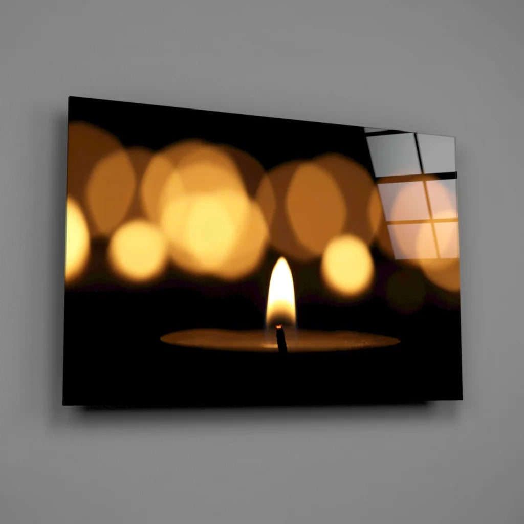 Lit candle glass wall art with warm flame and golden bokeh lights