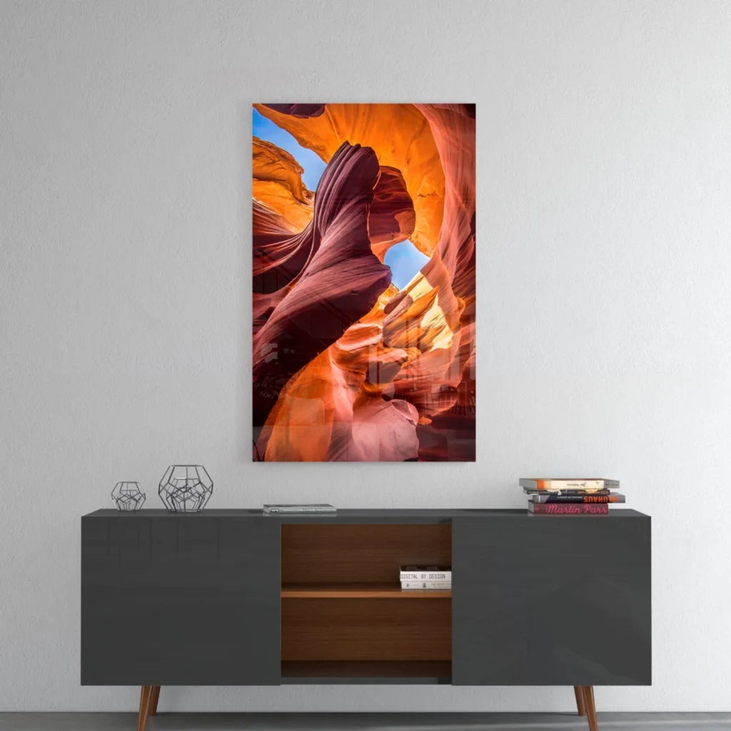 Vibrant orange red glass wall art of canyon above gray console