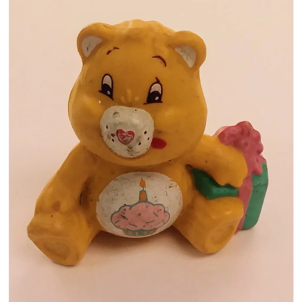 Yellow Care Bears mini figure holding birthday cake with heart on chest