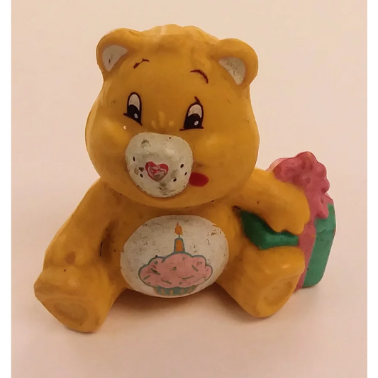 Yellow Care Bears mini figure holding birthday cake with heart on chest