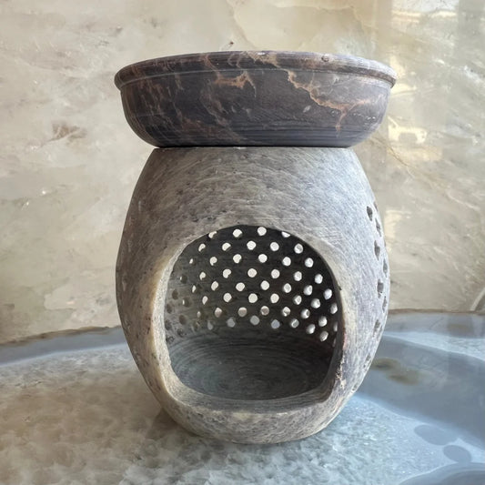 Carved soapstone essential oil burner with dark brown marble top and perforated base