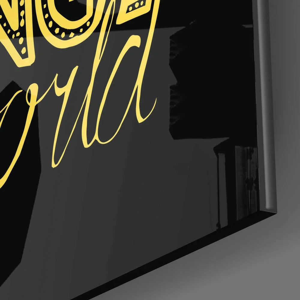 Sleek black glass wall art with bold gold cursive world quote