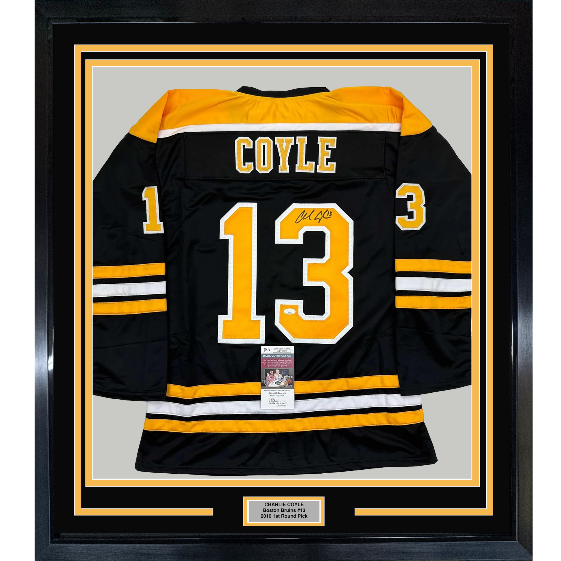 Framed black Boston Bruins hockey jersey number 13 with "COYLE" nameplate and signature, displayed flat against gray background with yellow and black border matting.