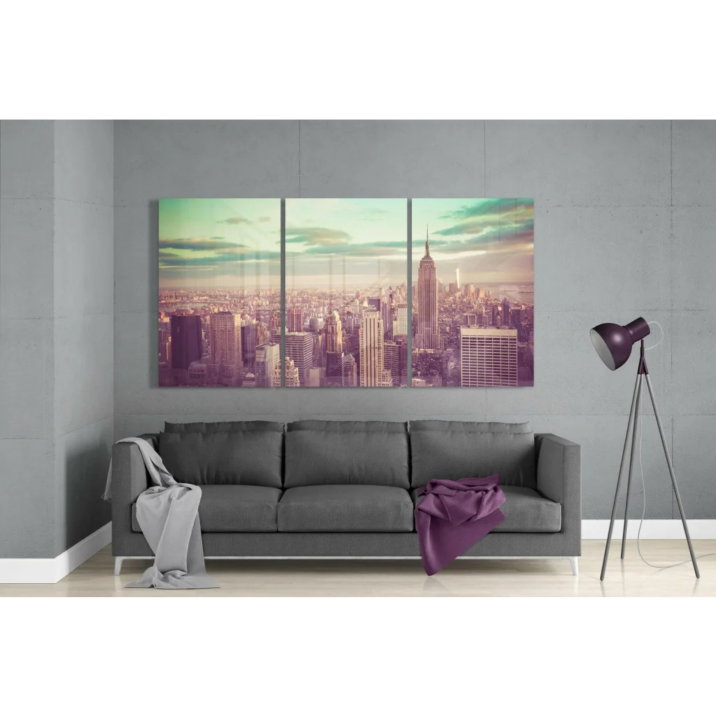 Stylized NYC Empire State triptych canvas wall art in pastel hues over gray sofa
