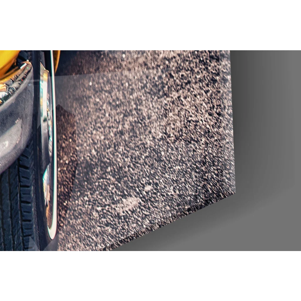 Vintage yellow taxi cab wall art with black tire on silver rim by asphalt