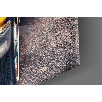 Vintage yellow taxi cab wall art with black tire on silver rim by asphalt