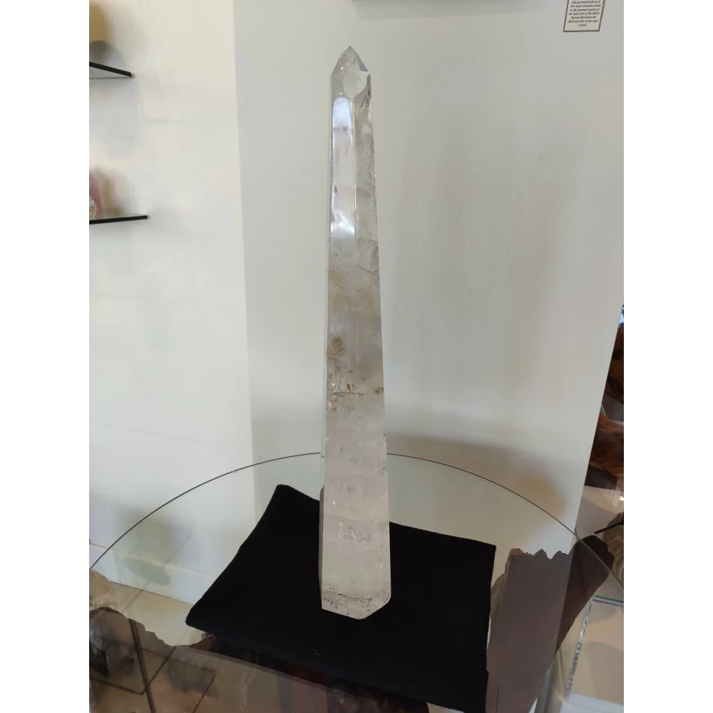 A clear quartz polished obelisk sculpture 20.5 inches tall with natural inclusions and a pointed top