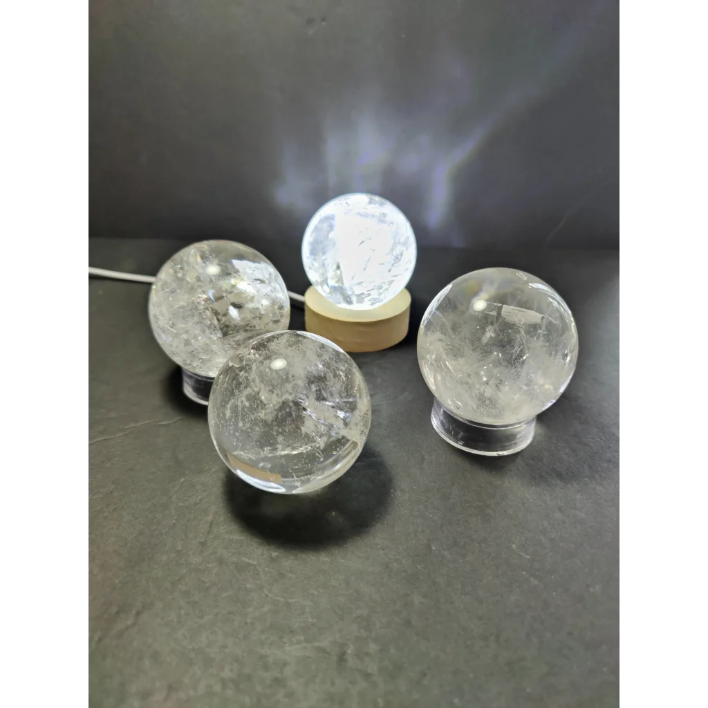 Clear quartz polished spheres displayed on wooden and clear acrylic stands as an extra quality polished sphere sculpture