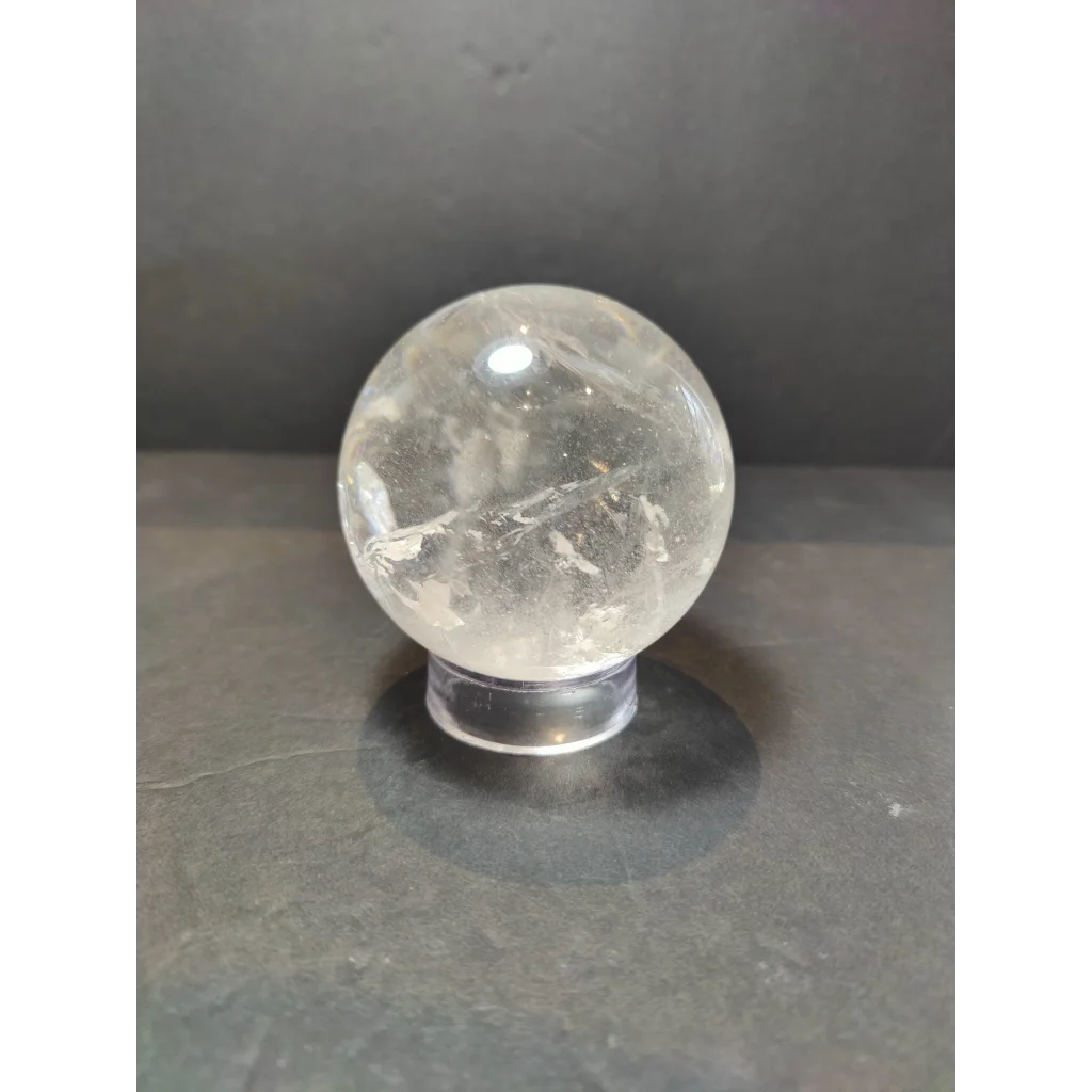 Clear quartz polished sphere sculpture with natural internal inclusions and a smooth translucent surface