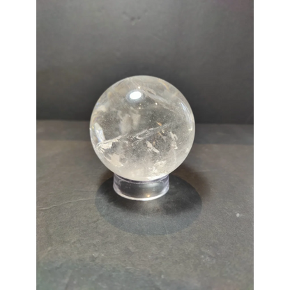 Clear quartz polished sphere sculpture with natural internal inclusions and a smooth translucent surface