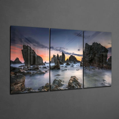 Three-panel coastal sunset wall art with rocks and misty water