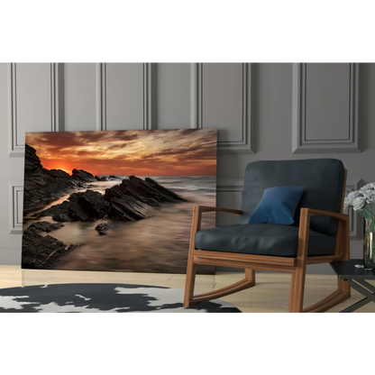 Fiery coastal sunset glass wall art over rugged rocks