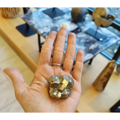 Close-up of cocada pyrite LG golden faceted crystals in open palm