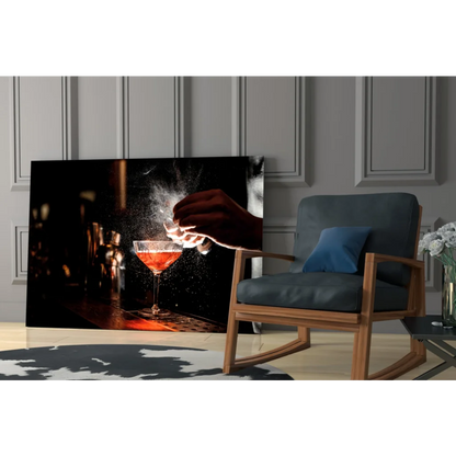 Black-framed canvas wall art of hand pouring red liquid into martini glass
