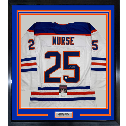 Framed white Edmonton Oilers hockey jersey number 25 with "NURSE" nameplate, navy and red stripes, displayed against blue matting with JSA authentication certificate.