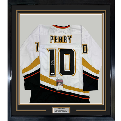 White Anaheim Ducks hockey jersey number 10 with "PERRY" nameplate, signed, displayed flat in black frame with gold matting and authentication certificate.