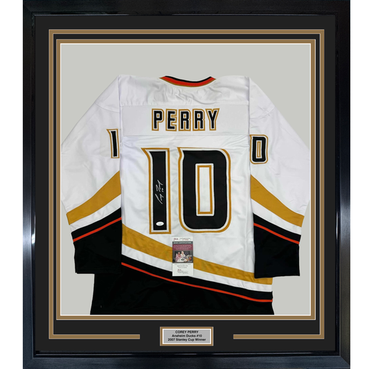 White Anaheim Ducks hockey jersey number 10 with "PERRY" nameplate, signed, displayed flat in black frame with gold matting and authentication certificate.