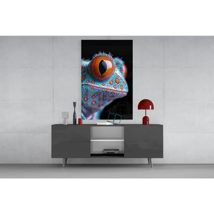 Vibrant turquoise and orange gecko eye glass wall art on gray console