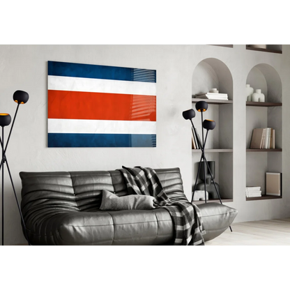 Modern leather sofa with checkered blanket under Costa Rican flag wall art