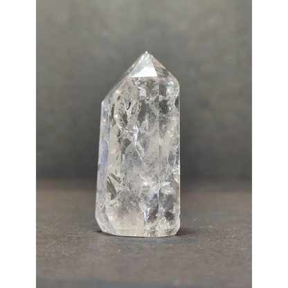 A clear faceted crackle quartz point tower with pointed top and natural internal inclusions in quartz crystal