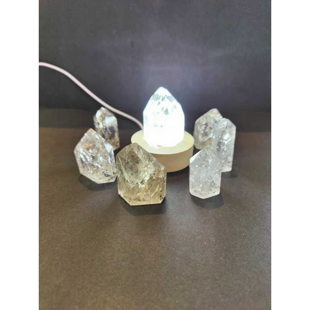 Clear quartz crackle quartz point cluster with central illuminated base showcasing natural translucent crystals