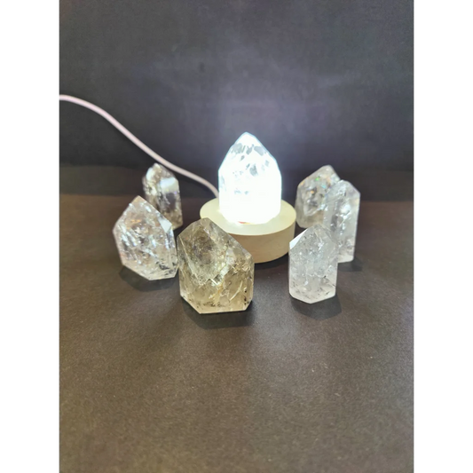 Clear quartz crackle quartz point cluster with central illuminated base showcasing natural translucent crystals