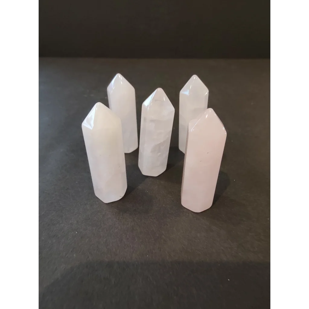 Five translucent white quartz crystal cut base tower points on dark surface