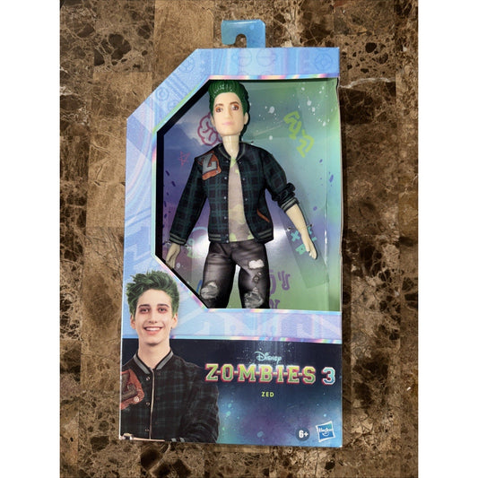 Disney Zombies 3 Zed fashion doll in packaging, displaying green-haired figure wearing black jacket and distressed pants against marble background.