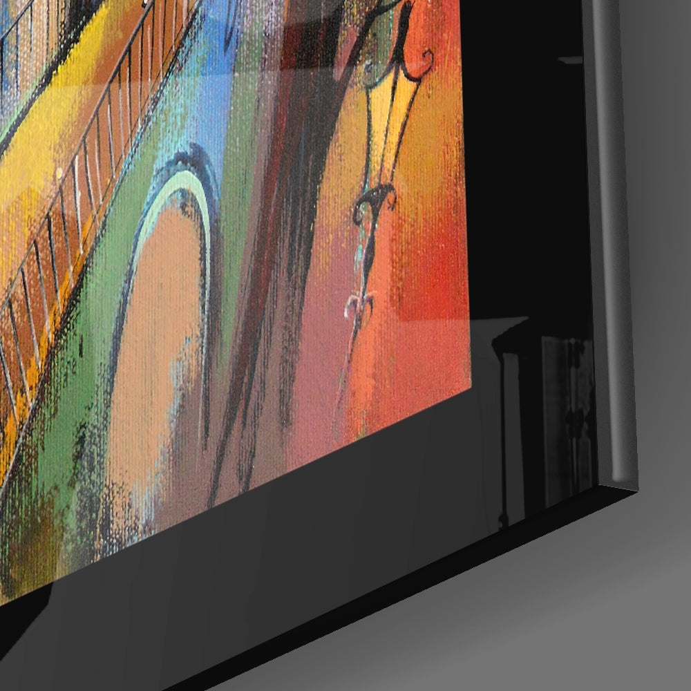 Close-up angled view of colorful glass wall art featuring yellow, blue, green, red, and orange striped pattern with decorative scrollwork details.