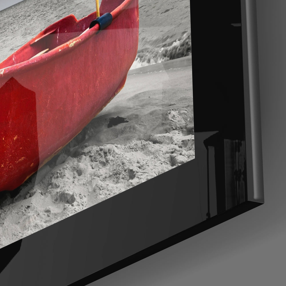Red boat with blue oar displayed on glass wall art showing sandy beach scene.