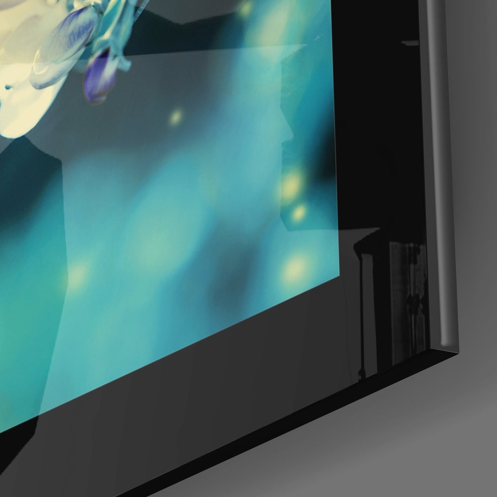 Close-up angled view of turquoise glass wall art with purple and white floral designs and yellow bokeh accents.