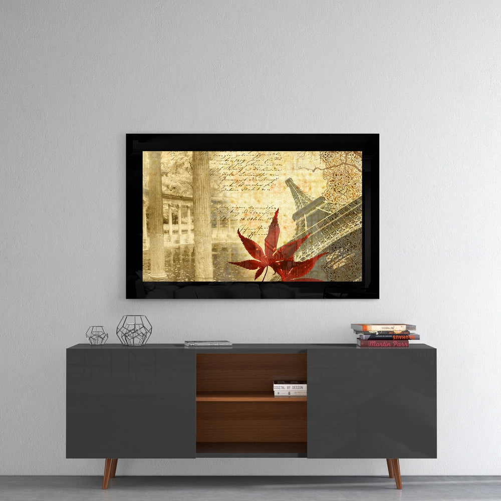 Framed glass wall art depicting sepia-toned Parisian architecture with red maple leaf in foreground, displayed above modern media console.