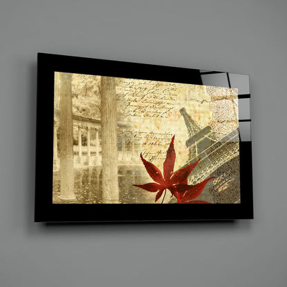 Black-framed glass wall art displaying sepia-toned Parisian architecture, handwritten script, ornate patterns, and a vibrant red maple leaf.