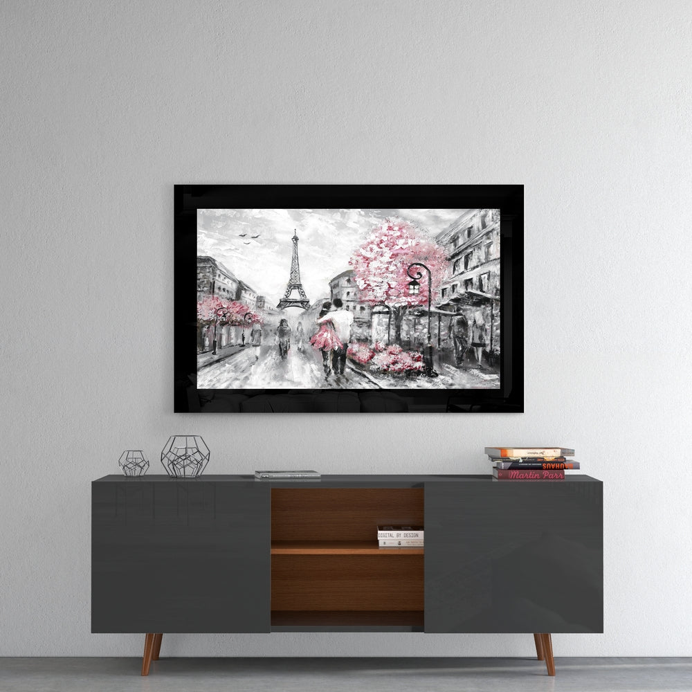 Black-framed glass wall art depicting a Paris street scene with Eiffel Tower and pink flowering trees mounted above a mid-century modern console table.